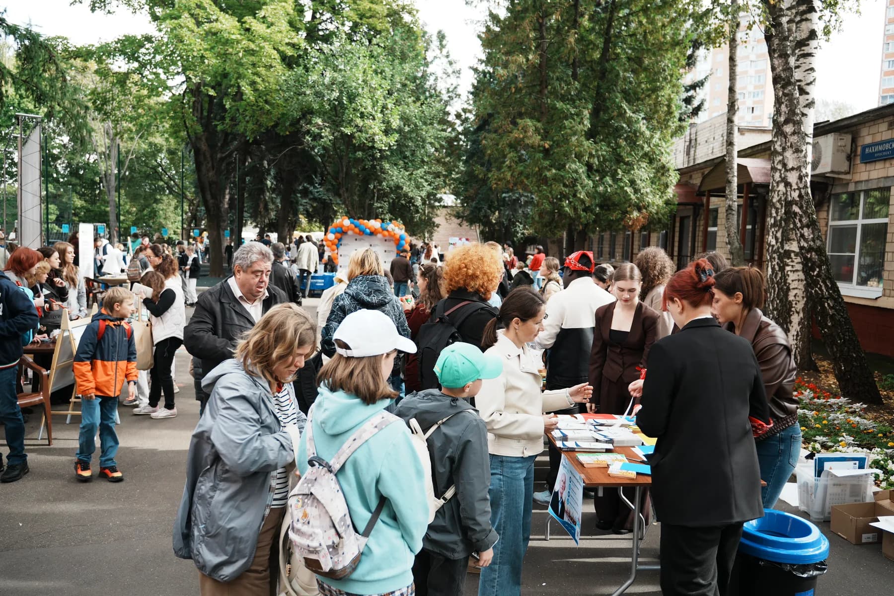 Families gathered along the festival avenue beside book tables and balloon arches