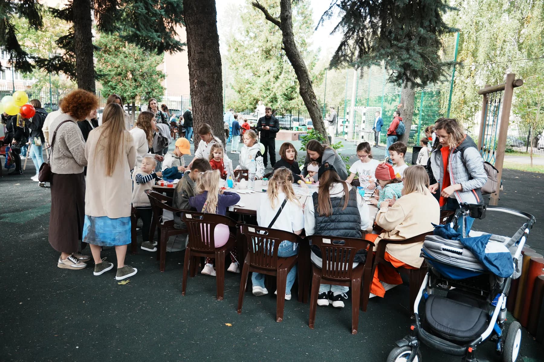 Children making crafts at long tables under the trees